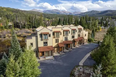 an aerial view of a building with mountains in the background at 102 Willows Way Townhouse in Winter Park