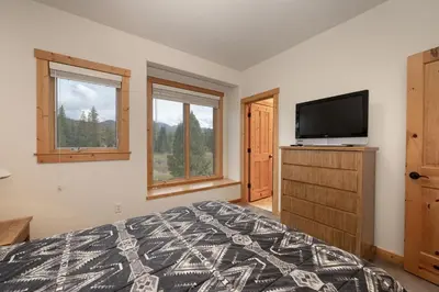 a bedroom with a bed and a flat screen tv at 102 Willows Way Townhouse in Winter Park