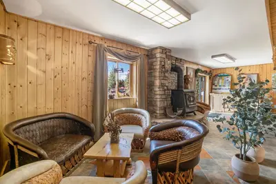 a living room with wooden walls and chairs and a table at Spirit Lake Lodge in Grand Lake