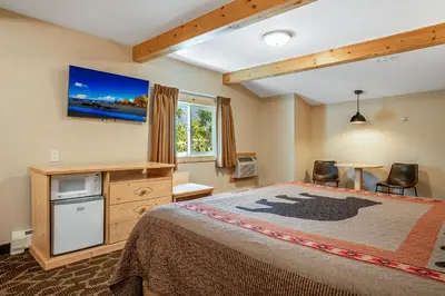 a bedroom with a bed and a tv on the wall at Spirit Lake Lodge in Grand Lake