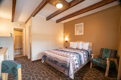 a hotel room with a bed and two chairs at Spirit Lake Lodge in Grand Lake