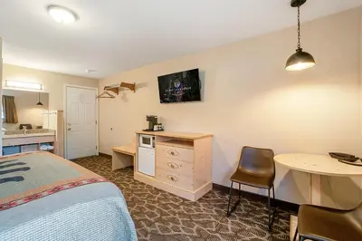 a bedroom with a bed and a desk and a table at Spirit Lake Lodge in Grand Lake