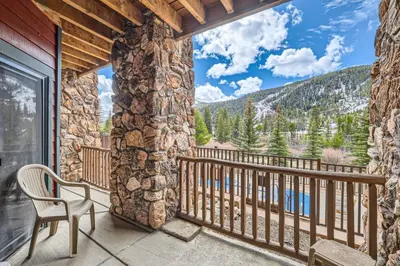 a balcony with a chair and a view of the mountains at Hidden River Lodge 5945 - Keystone in Keystone