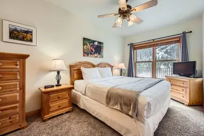 a bedroom with a bed with a ceiling fan and a tv at Hidden River Lodge 5945 - Keystone in Keystone