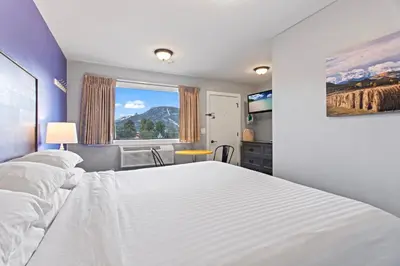 a bedroom with a large white bed and a window at Coyote Mountain Lodge in Estes Park