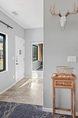 a living room with a table and a hallway at Coyote Mountain Lodge in Estes Park