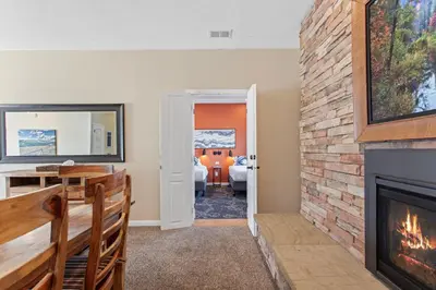 a living room with a fireplace and a bedroom at Coyote Mountain Lodge in Estes Park