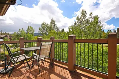 a deck with two chairs and a table on a fence at Highland Greens Lodge 305 Condo in Breckenridge