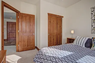 a bedroom with a bed and wooden doors at Highland Greens Lodge 305 Condo in Breckenridge
