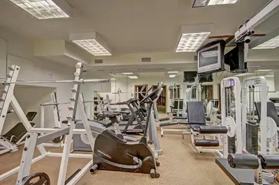 a gym with treadmills and exercise equipment and a television at Highland Greens Lodge 305 Condo in Breckenridge