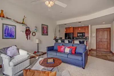 a living room with a blue couch and a table at Highland Greens Lodge 305 Condo in Breckenridge