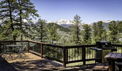 a balcony with a grill and a view of mountains at Tranquil Duplex Home in Estes Park