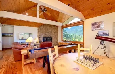 a living room with a chess board on a table at Tranquil Duplex Home in Estes Park