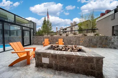a patio with a fire pit and two orange chairs at Snowblaze Condos Building A unit 33 in Winter Park
