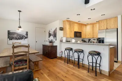 a kitchen with a table and a counter with bar stools at Snowblaze Condos Building A unit 33 in Winter Park