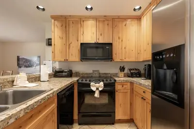 a kitchen with wooden cabinets and a black stove top oven at Snowblaze Condos Building A unit 33 in Winter Park