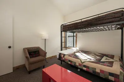 a bedroom with a bunk bed and a chair at Snowblaze Condos Building A unit 33 in Winter Park
