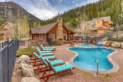 a pool with lounge chairs and a house at Settler's Creek 6524 in Keystone