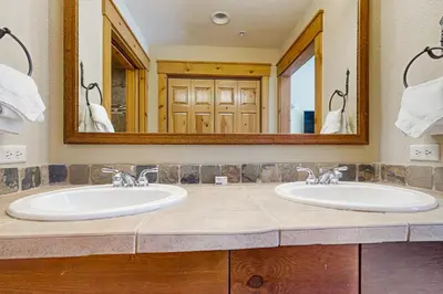 a bathroom with two sinks and a large mirror at Settler's Creek 6524 in Keystone