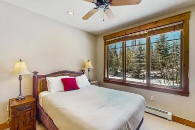 a bedroom with a bed with a ceiling fan and a window at Settler's Creek 6524 in Keystone