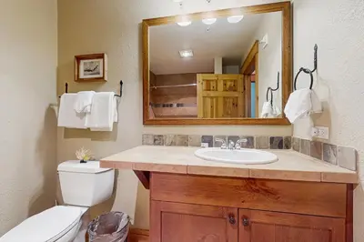 a bathroom with a sink and a toilet and a mirror at Settler's Creek 6524 in Keystone