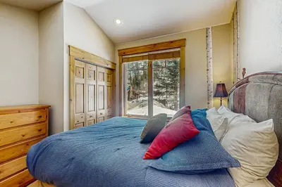 a bedroom with a blue bed with pillows on it at Settler's Creek 6524 in Keystone