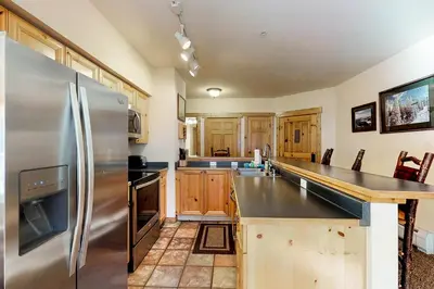 a kitchen with a stainless steel refrigerator and wooden cabinets at Tenderfoot Lodge 2621 in Keystone