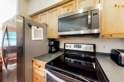 a kitchen with a stove and a microwave at Tenderfoot Lodge 2621 in Keystone