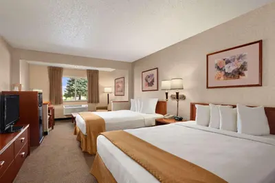 a hotel room with two beds and a television at Baymont by Wyndham Golden/Red Rocks in Lakewood