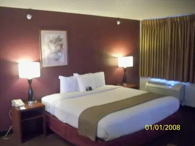 a hotel room with a large bed with two lamps at Baymont by Wyndham Golden/Red Rocks in Lakewood