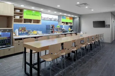 a cafeteria with a long table and chairs at Home2 Suites By Hilton Denver South Centennial Airport in Centennial