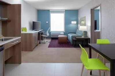 a room with a living room with a couch and a table at Home2 Suites By Hilton Denver South Centennial Airport in Centennial