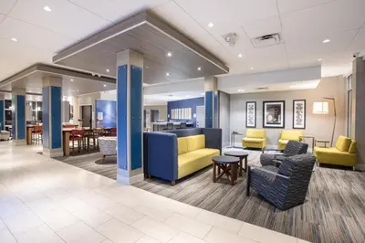 a lobby of a hospital with chairs and tables at Holiday Inn Express & Suites - Denver NE - Brighton by IHG in Brighton