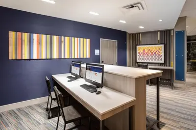 an office cubicle with two computer monitors on a desk at Holiday Inn Express & Suites - Denver NE - Brighton by IHG in Brighton