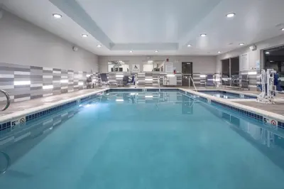 a large swimming pool with blue water at Holiday Inn Express & Suites - Denver NE - Brighton by IHG in Brighton