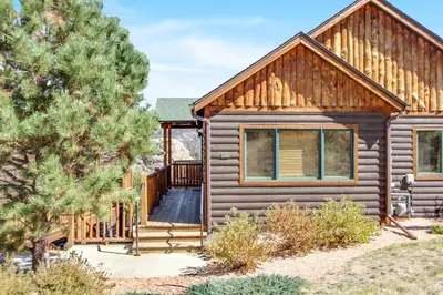 a log cabin with a porch and a deck at The Twin Owls 21A Condo in Estes Park