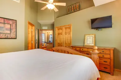 a bedroom with a bed and a flat screen tv at The Twin Owls 21A Condo in Estes Park