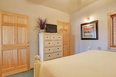 a bedroom with a bed and a dresser with a television at Sheep Mountain 20B Condo in Estes Park