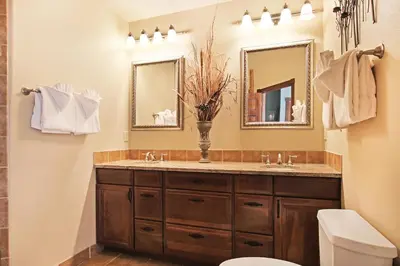 a bathroom with a sink and a toilet and mirrors at Mount Chiquita 10A Condo in Estes Park