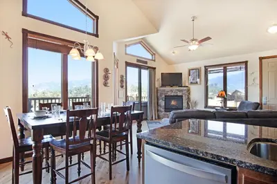 a kitchen and living room with a table and chairs at Mount Chiquita 10A Condo in Estes Park