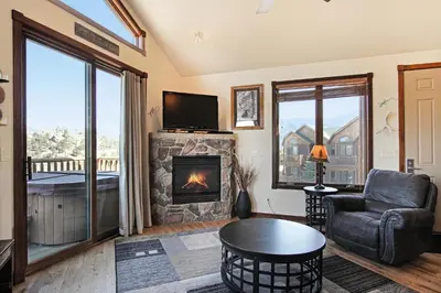 a living room with a fireplace and a television at Mount Chiquita 10A Condo in Estes Park