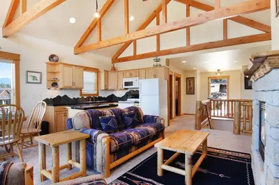 a living room with a couch and a kitchen at Comanche Peak 39 Condo in Estes Park