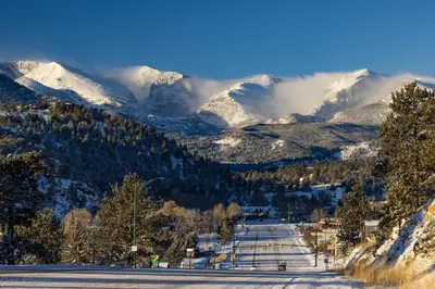 a snow covered mountain range with snow covered mountains at Comanche Peak 39 Condo in Estes Park