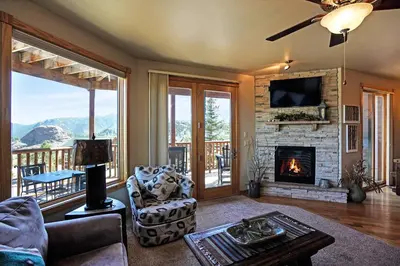 a living room with a fireplace and a tv at Bighorn Mountain 19B Condo in Estes Park