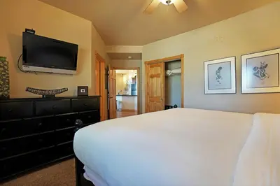 a bedroom with a bed and a flat screen tv at Bighorn Mountain 19B Condo in Estes Park