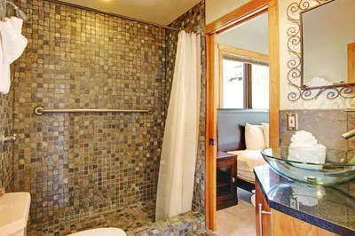 a bathroom with a shower and a glass sink at Mount Cairns 16A Condo in Estes Park