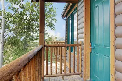 a porch with a blue door and a view at Mount Cairns 16A Condo in Estes Park