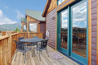 a patio with a table and chairs on a deck at Mount Cairns 16A Condo in Estes Park