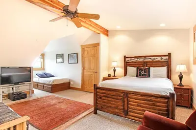a bedroom with a bed and a flat screen tv at Mount Chapin S4 Condo in Estes Park