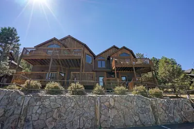 a large log home with a stone wall at Mount Meeker 26B Condo in Estes Park